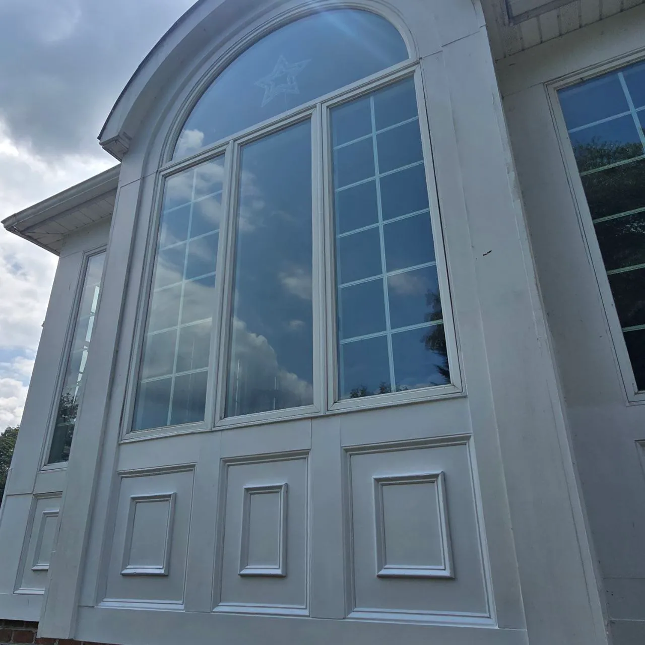 Arched palladian window wall reflecting the sky